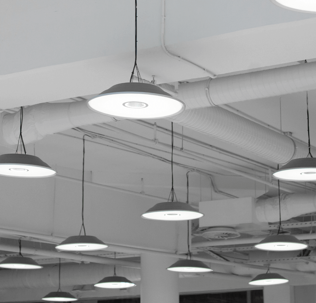 Ceiling with hanging pendant lights and exposed ductwork in monochrome
